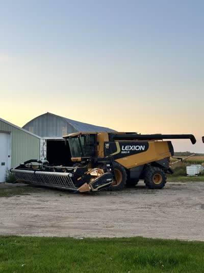 Combine parked by the machine shed at dusk